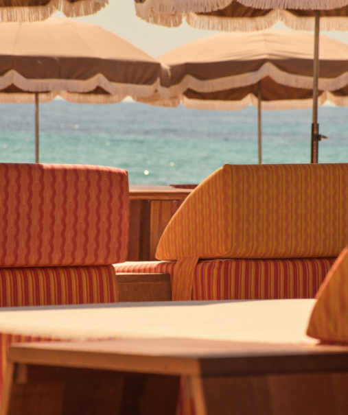 Parasols et transats de la plage privée Indie Beach Pampelonne vus en contre-plongée